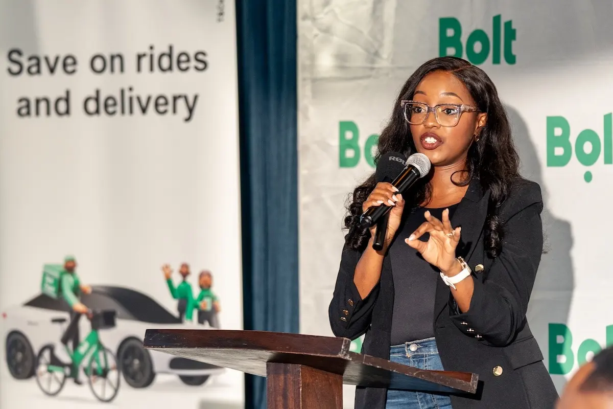 Bolt Food Kenya general manager Ivy Njeri Maingi speaking at a lectern in front of Bolt banners at the Bolt Plus launch