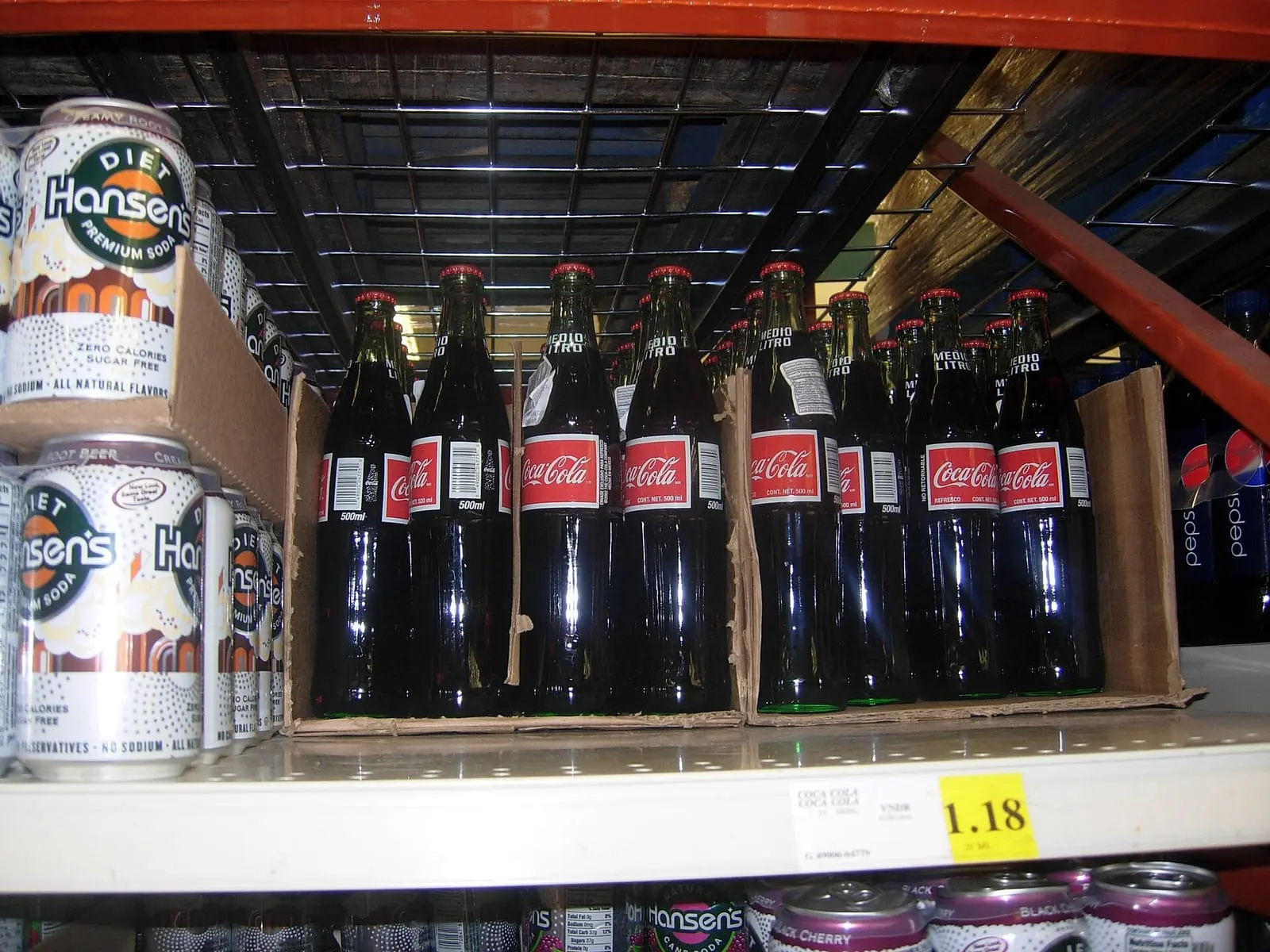 Rows of Coca-Cola bottles on a shop shelf