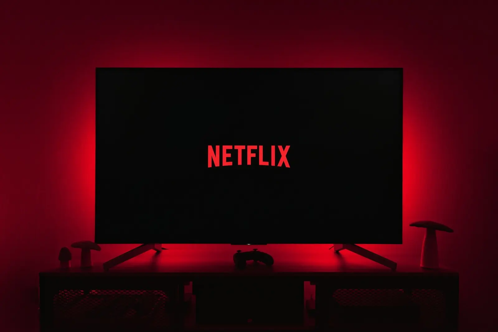 A television showing the Netflix logo in a dark room lit with red light