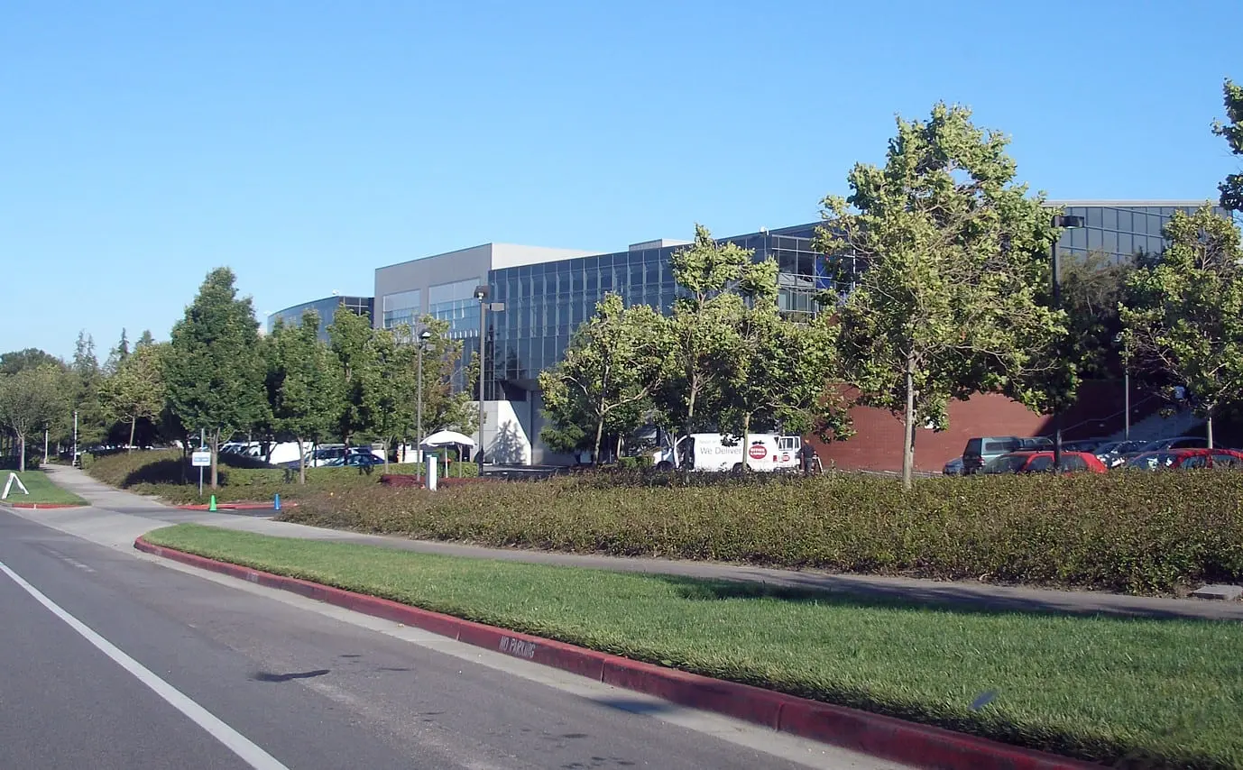 Google office buildings at the Googleplex campus behind trees