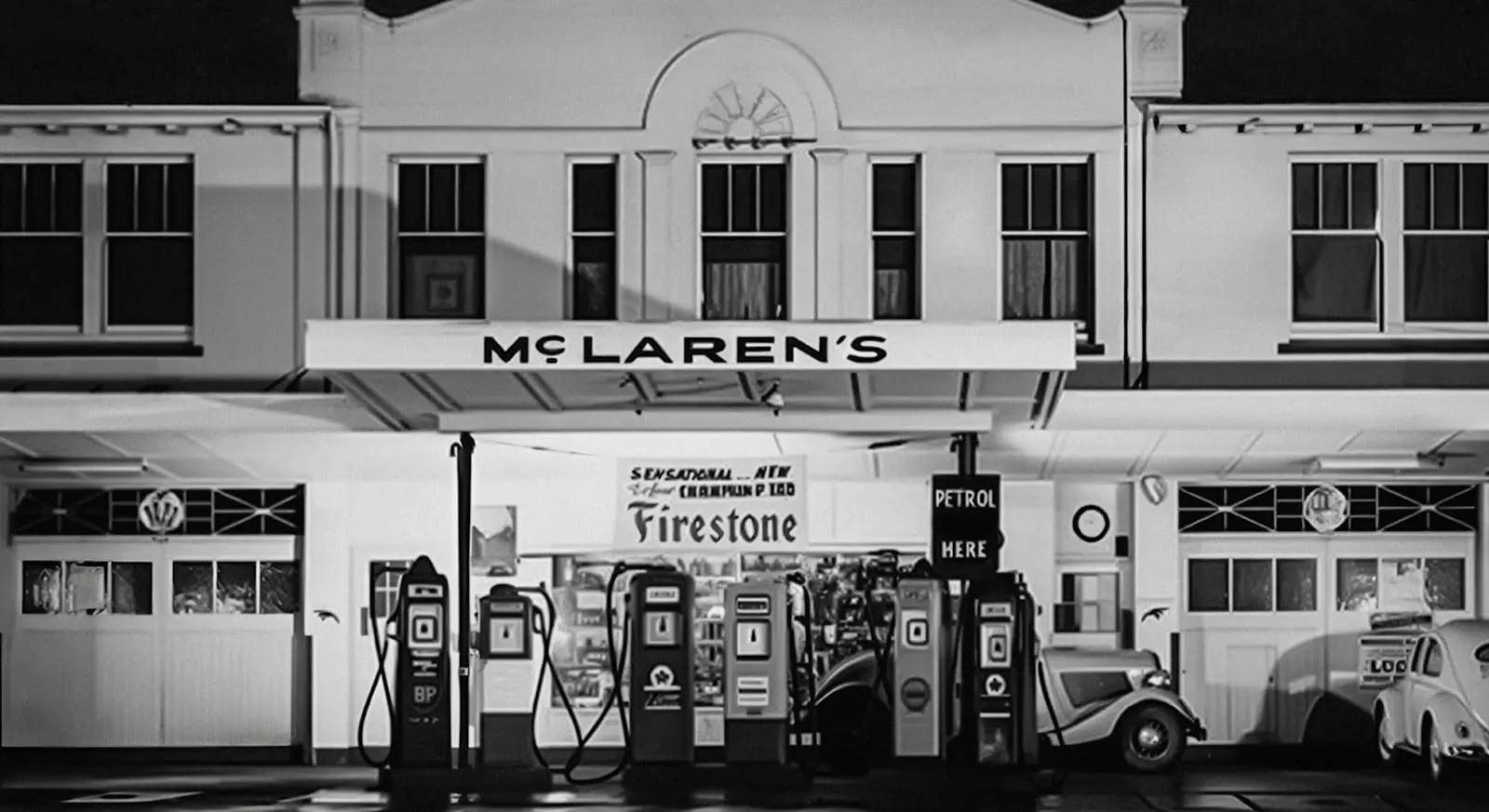 Black and white photo of the McLaren family service station with petrol pumps out front