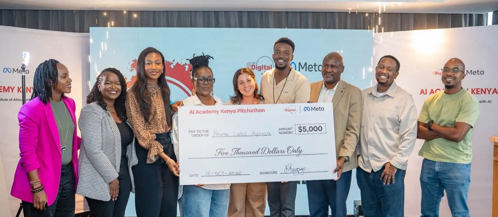 Nine people on a stage in Nairobi hold a giant cheque for $5,000 made out to Neural Labs Africa at the AI Academy Kenya Pitchathon