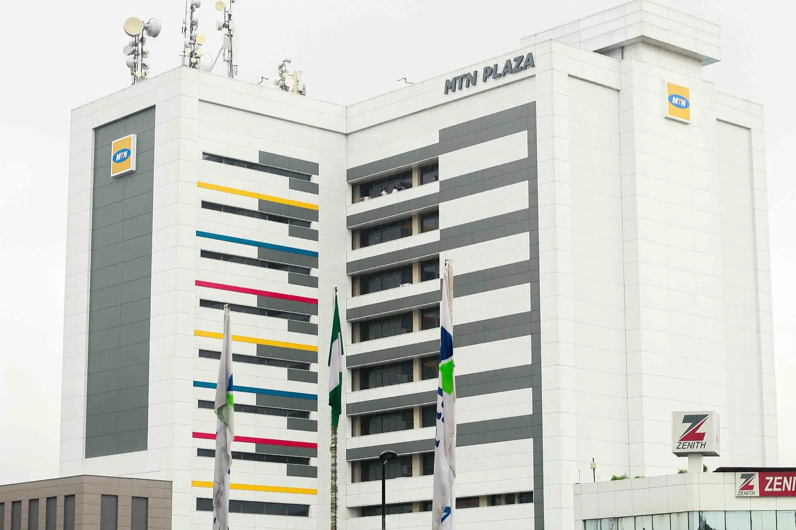 MTN Plaza, MTN Nigeria's white head office tower in Falomo, Lagos, with the yellow MTN logo and flags in front
