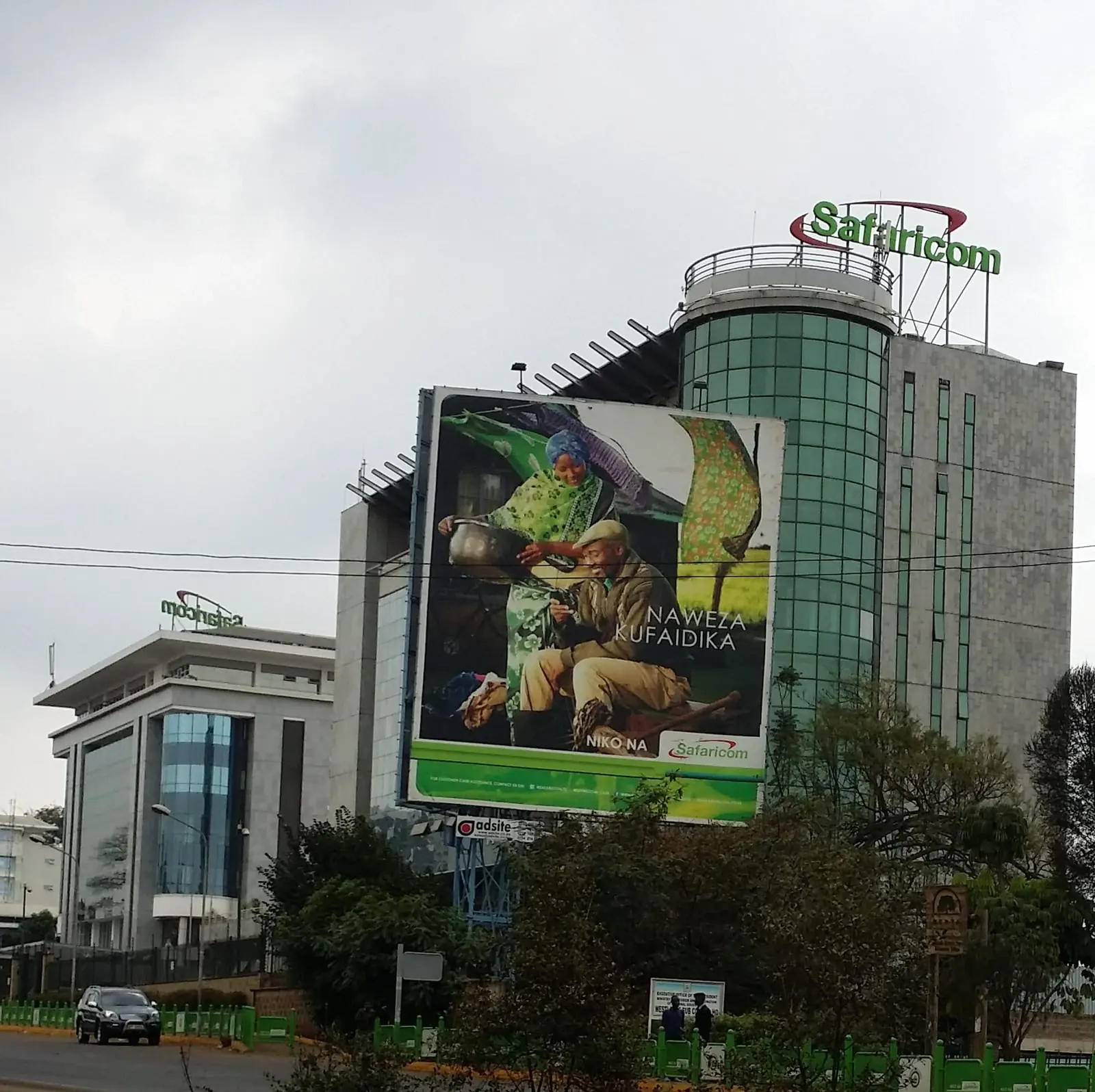 Safaricom's headquarters building in Nairobi with a large billboard in front