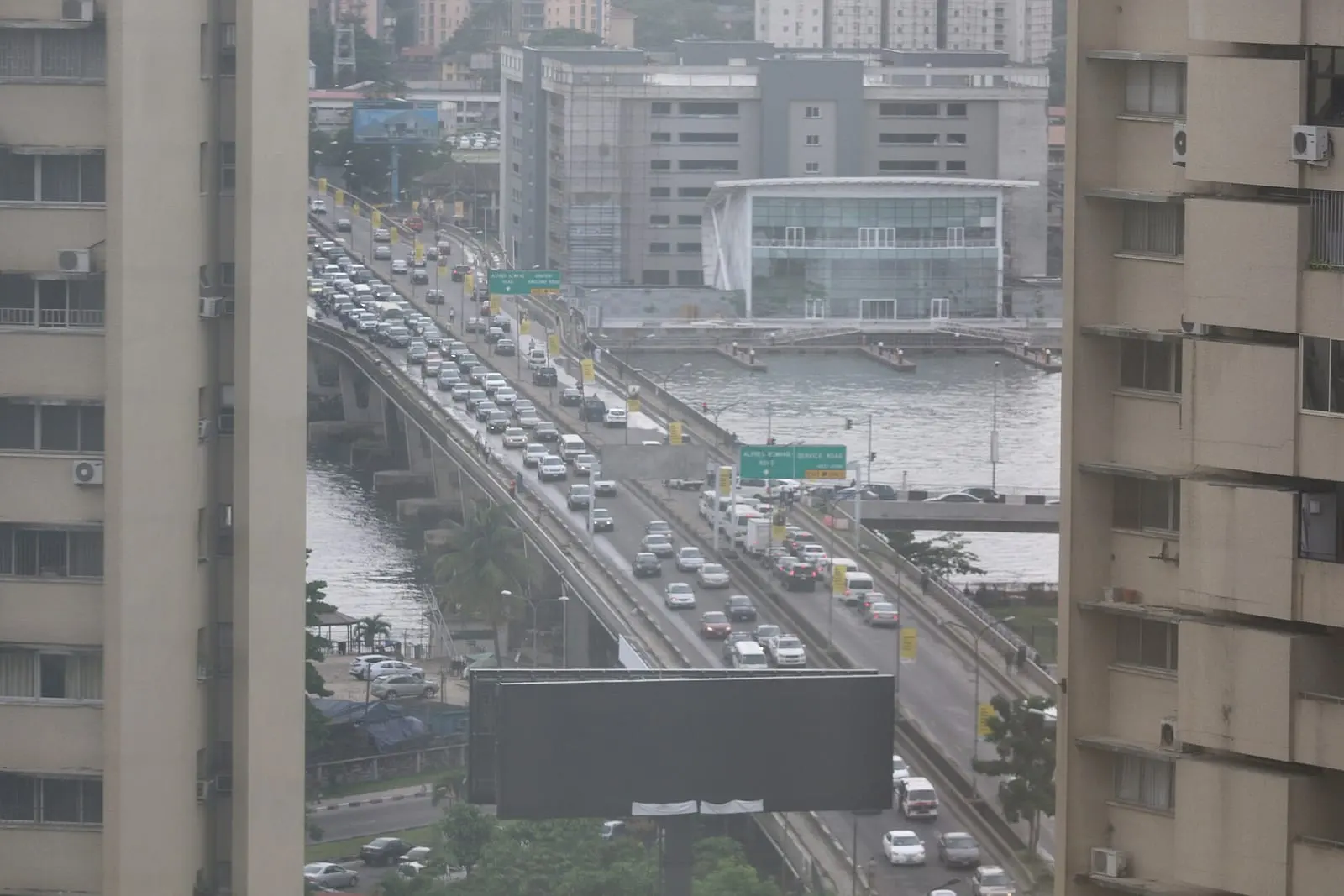 Cars and buses in early morning traffic on a Lagos road